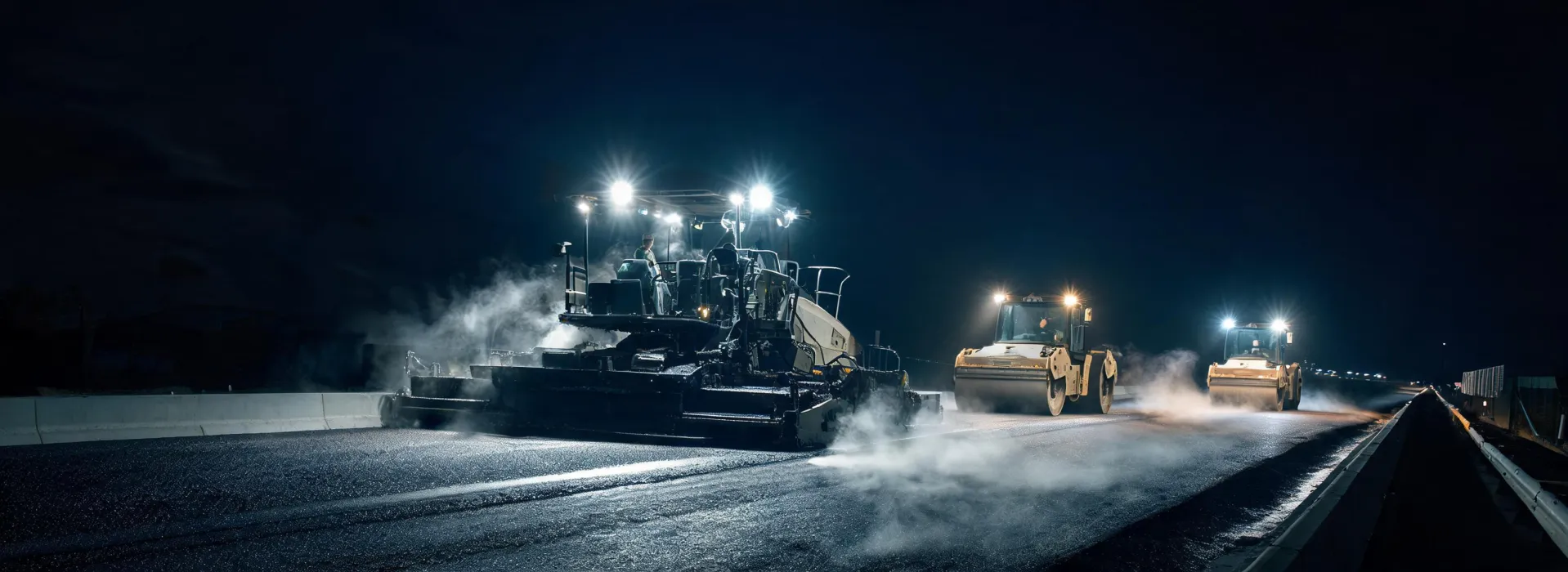 Night asphalt paving with paver and rollers on highway